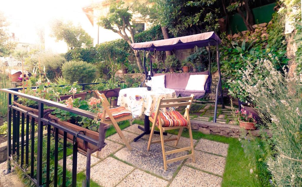 um jardim com uma mesa e cadeiras e um guarda-sol em Apartment Johanna em Opatija