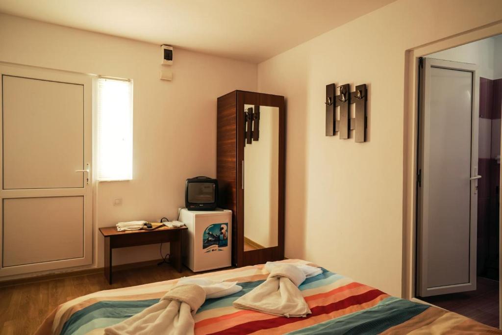 1 dormitorio con 1 cama con toallas en Vila Aty & Michelle, en Vama Veche