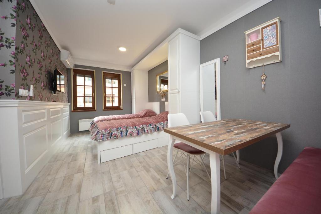 a dining room with a table and a bed at Best of Bascarsija apartments in Sarajevo