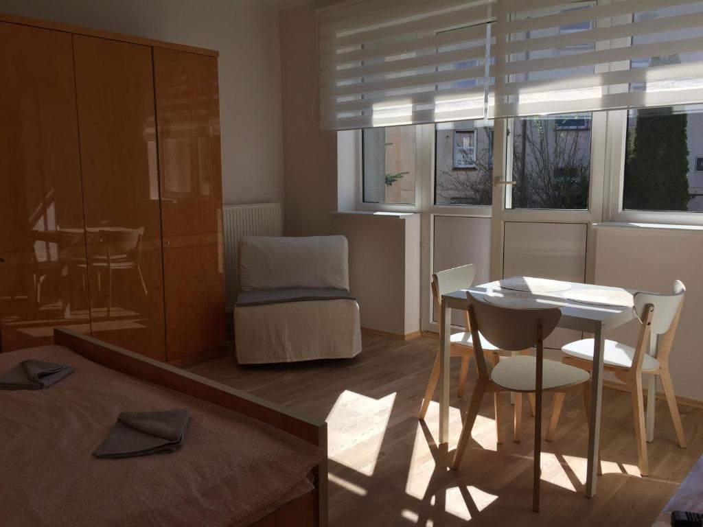 グディニャにあるWilla Przy Plaży Gdynia Kamienna Góraのリビングルーム(テーブル、椅子付)、ベッドルーム1室が備わります。
