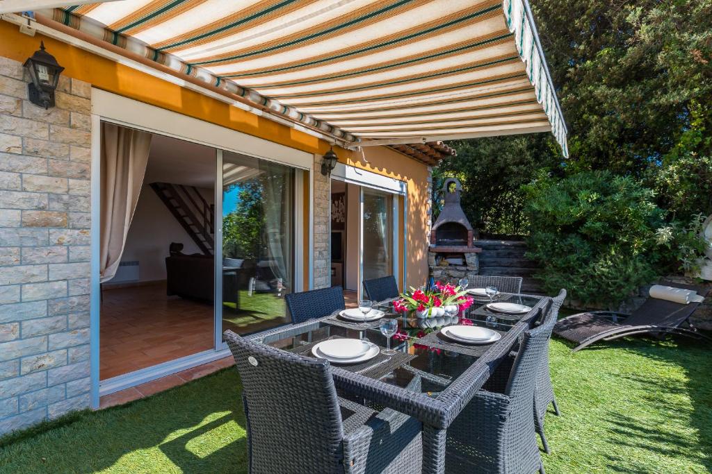 a patio with a table with chairs and an umbrella at Sleep In Biot in Biot