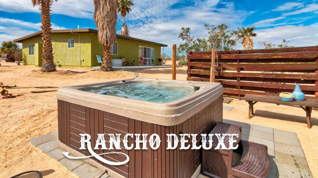 una bañera de hidromasaje en un patio con un banco y una casa en Rancho Deluxe en Twentynine Palms
