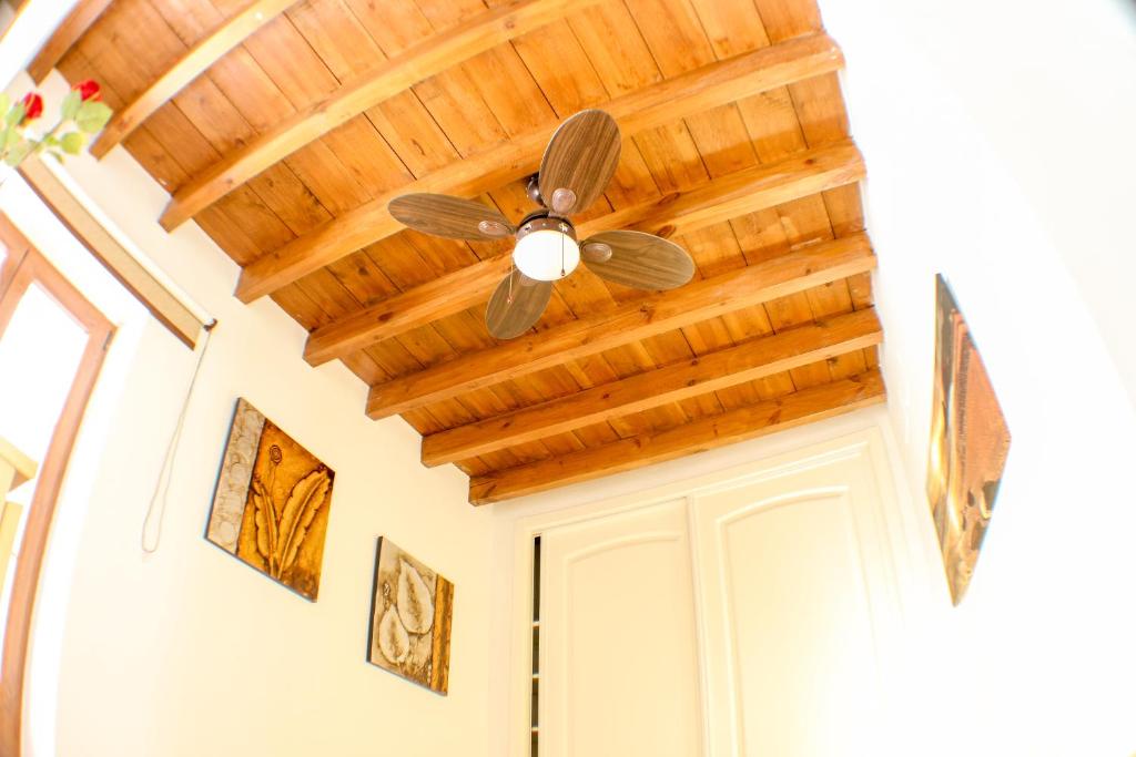 a ceiling fan in a hallway with wooden ceilings at Calle Santa Marina 6 in Seville