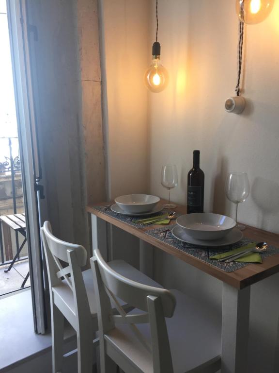 - une table avec 2 assiettes blanches et des verres à vin dans l'établissement Le Casette Gargallo 2 - Ortigia, à Syracuse