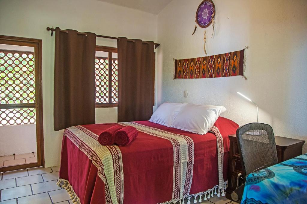 a bedroom with a bed with a red blanket at Casa Lucas in Sayulita
