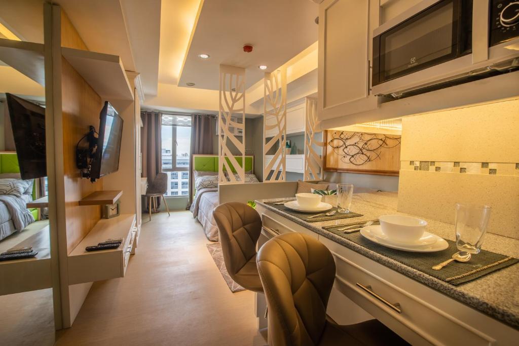 ein Wohnzimmer mit einer Küche mit einer Theke und Stühlen in der Unterkunft Avida Towers Cebu 2016 Wifi 190mbps, Netflix 50 in SmartTV in Cebu City