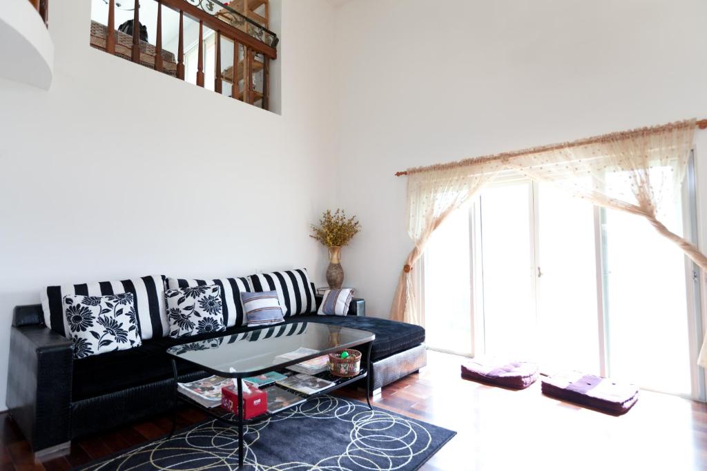 sala de estar con sofá negro y mesa en Alice Springs Homestay, en Tianfu