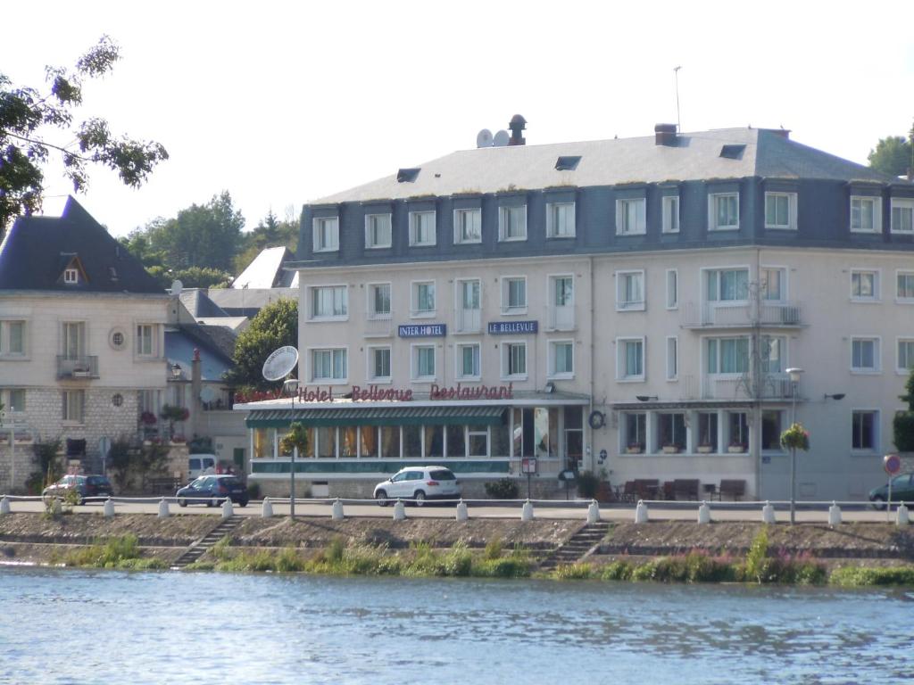 Hôtel Le Bellevue Montrichard 3 étoiles في مونتريشار: مبنى ابيض كبير بجانب نهر