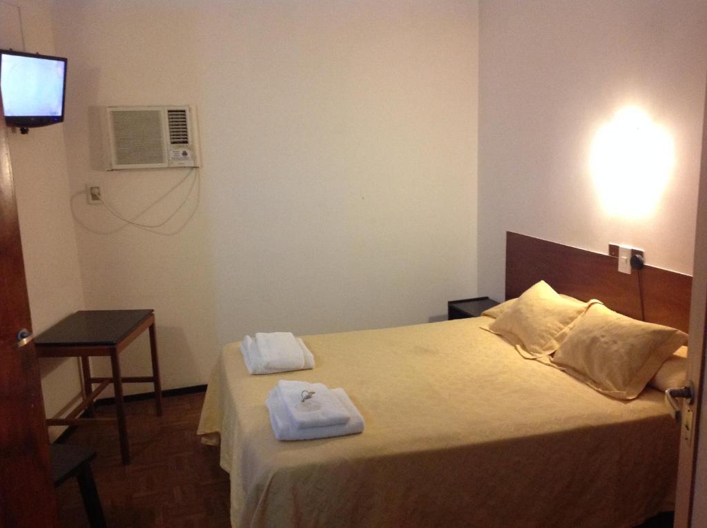 a hotel room with a bed with towels on it at Hotel Regidor in San Luis