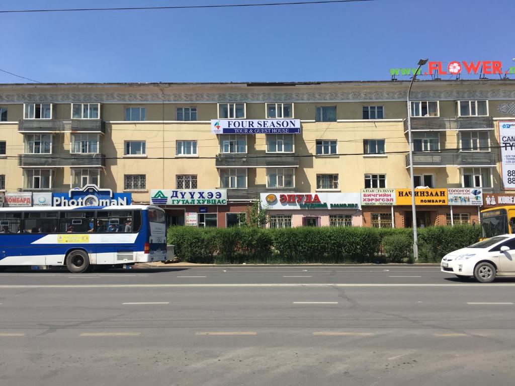Ein Bus steht vor einem Gebäude. in der Unterkunft Four Season in Ulaanbaatar