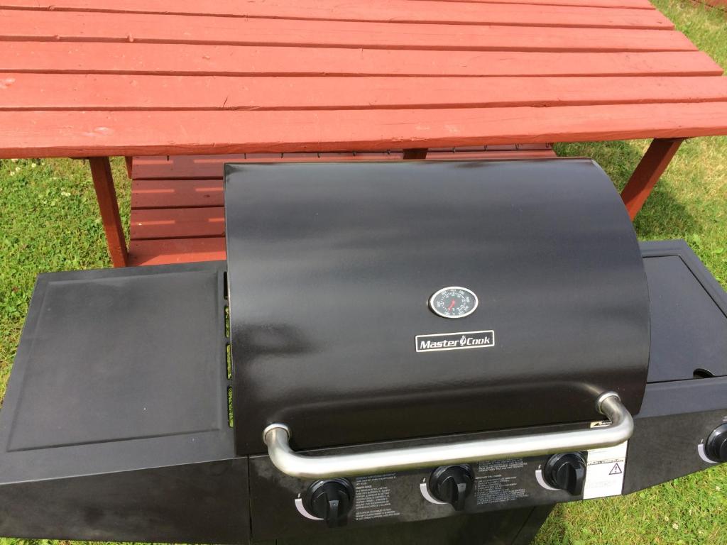 a bbq grill sitting under a picnic table at Hotel Motel Bonsoir in Granby