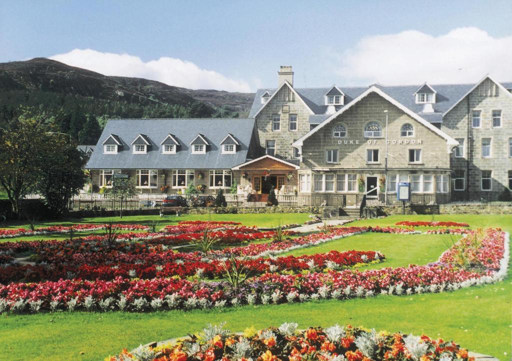 a large house with a garden in front of it at Duke Of Gordon Hotel in Kingussie
