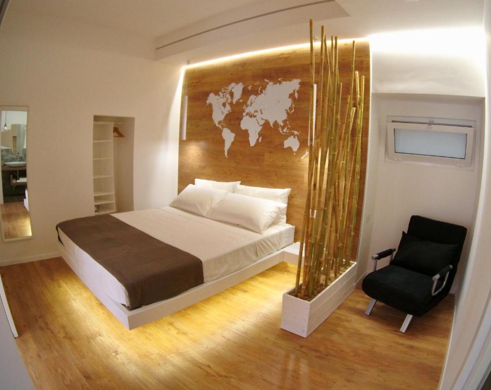 a bedroom with a large bed and a chair at Ragusa 2 al mare in Marina di Ragusa