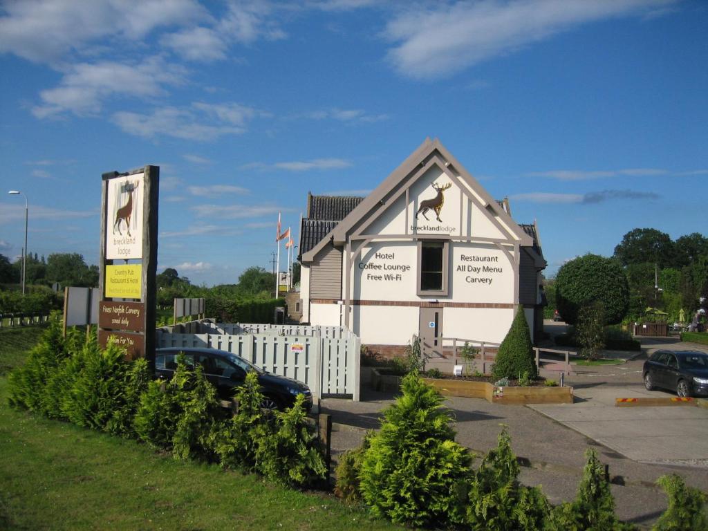 un edificio blanco con un caballo a un lado en Breckland Lodge en Attleborough