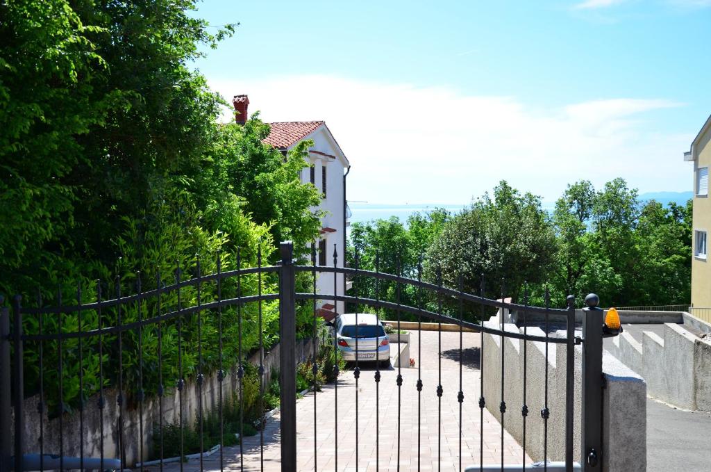 a gate with a car parked in a driveway at Green Apartments in Matulji