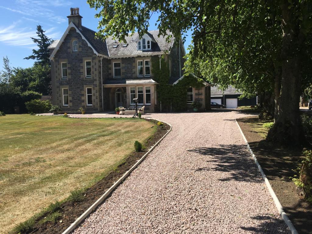 an old house with a tree and a gravel driveway at Mount Barker in Grantown on Spey