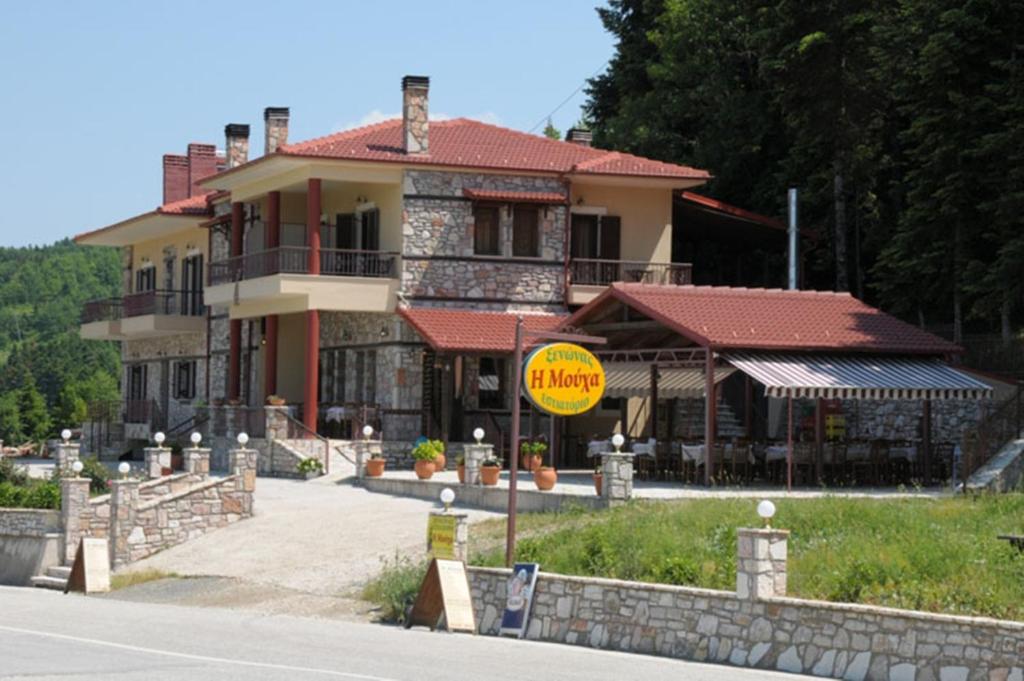 une maison sur le côté d'une route avec un panneau jaune dans l'établissement Guesthouse Moucha, à Moúcha