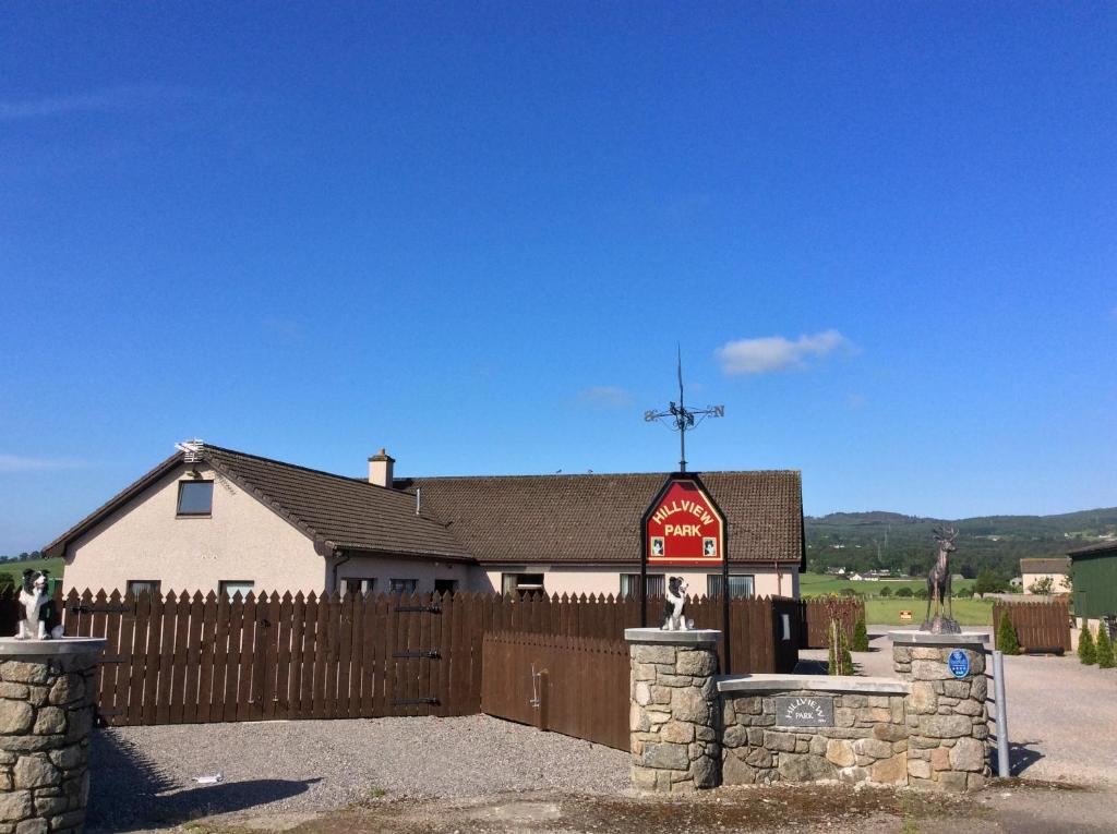 una iglesia con una valla y una cruz en la parte superior en Hillview Park, en Beauly