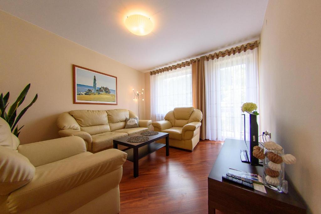 a living room with two couches and a table at Villa Turris in Muszyna