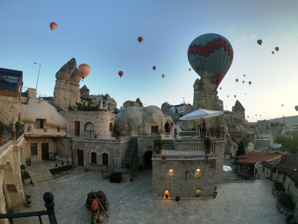 un grupo de globos de aire caliente volando en el cielo en Grand Cave Suites, en Göreme