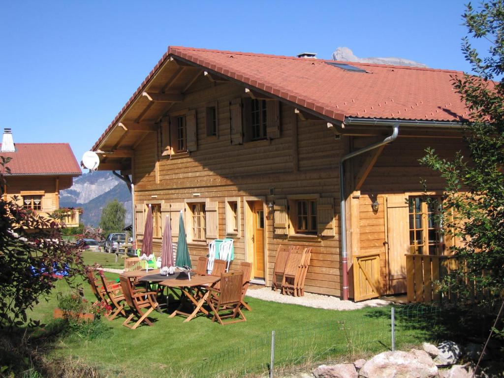 a wooden house with a table and chairs in the yard at Chalet Le Sabot De Venus in Combloux