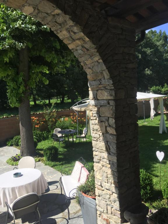 a stone archway with a table and chairs in a yard at Cà 'd Gnese in Castagnole Lanze