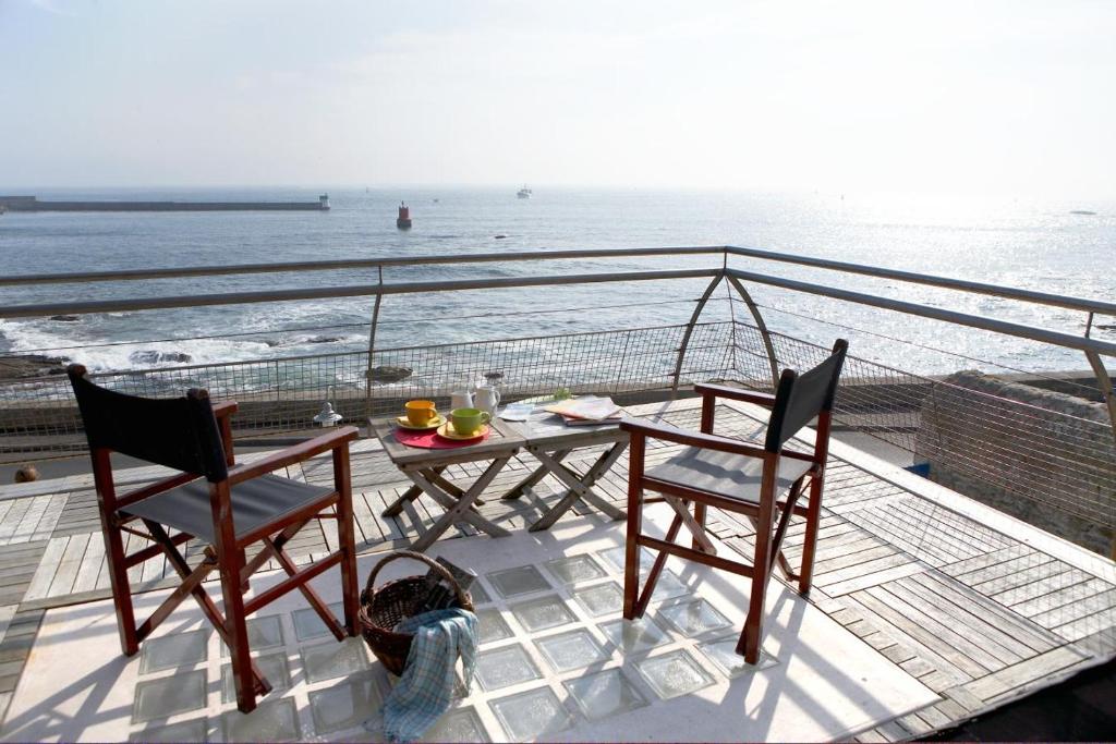 Un balcón con una mesa y dos sillas y el océano en Le Poisson d'Avril, en Le Guilvinec