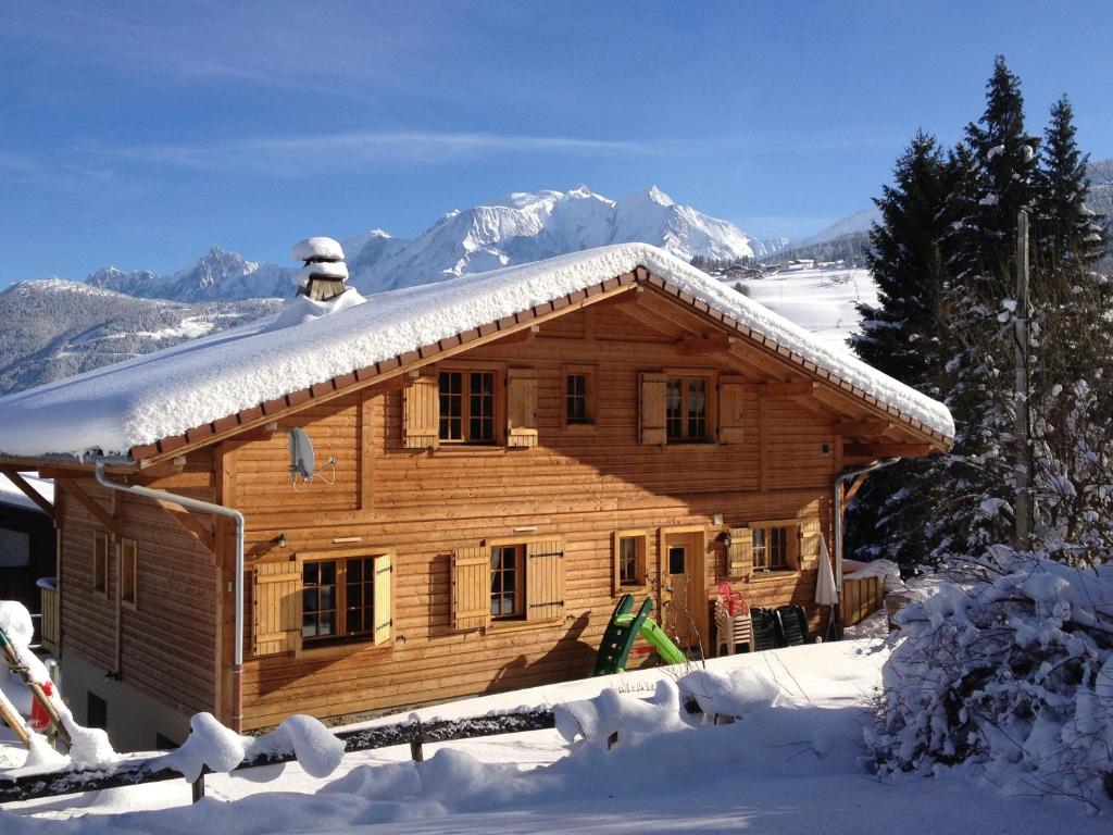 une cabane en rondins avec de la neige sur le toit dans l'établissement Chalet Le Sabot De Venus, à Combloux