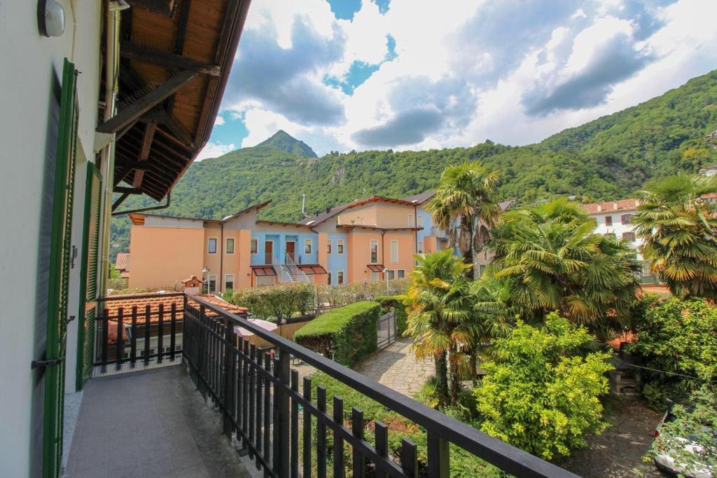a balcony with a view of a town with mountains at le palme in Cannero Riviera