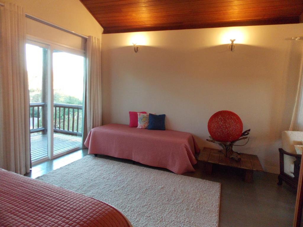 a bedroom with a bed and a balcony at Pouso Mantiqueira in Cunha
