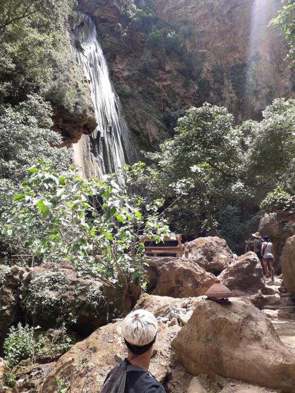 a man looking down at a waterfall on a mountain at Hostal La Joya in Chefchaouene