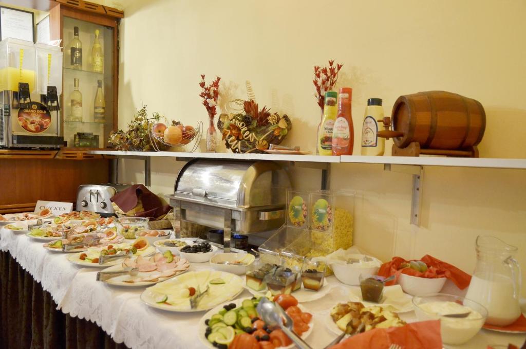 a buffet with plates of food on a table at Hotel Transilvania in Cluj-Napoca