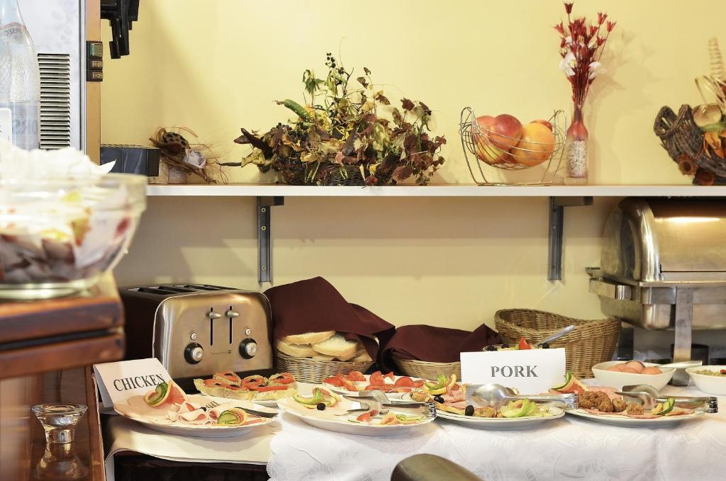 a buffet with plates of food on a table at Hotel Transilvania in Cluj-Napoca