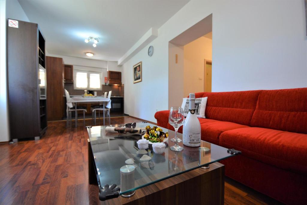 sala de estar con sofá rojo y mesa en Apartment Korina, en Zadar
