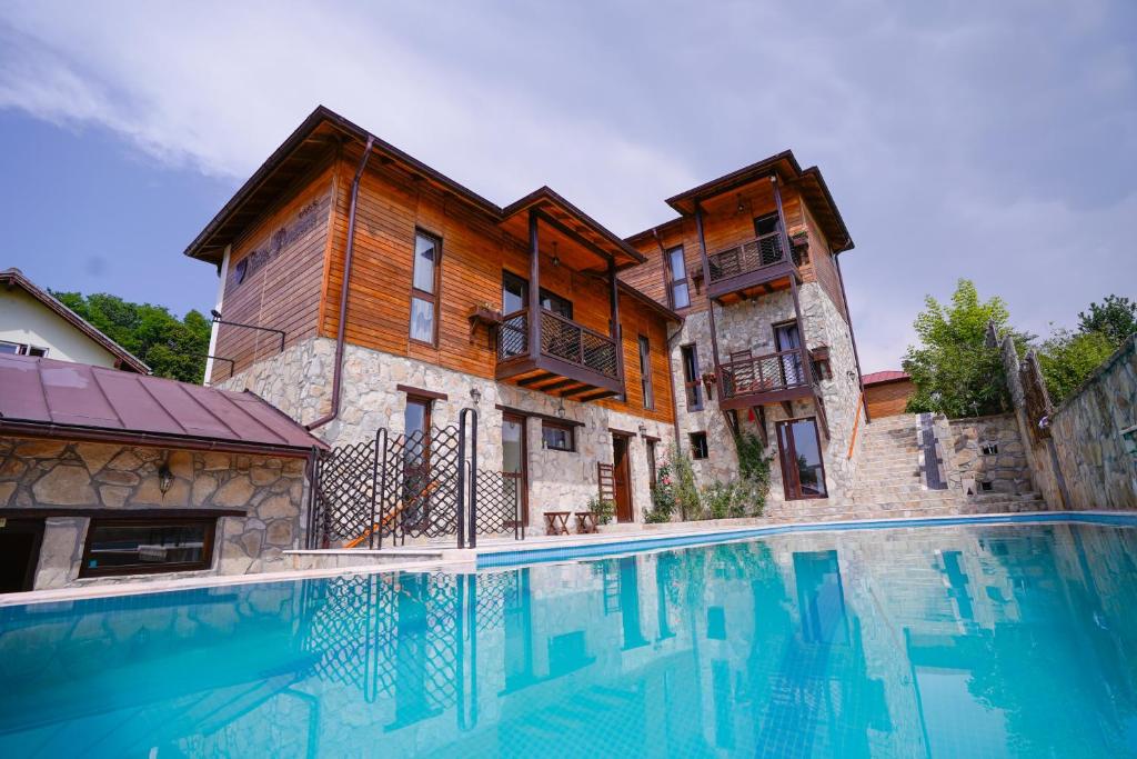 a large swimming pool in front of a building at Felix Pension in Băile Govora