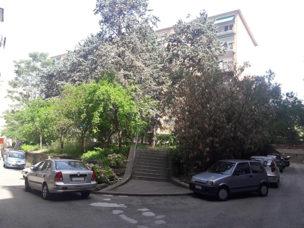 dos autos estacionados en un estacionamiento frente a un edificio en Casa Micol, en Trieste
