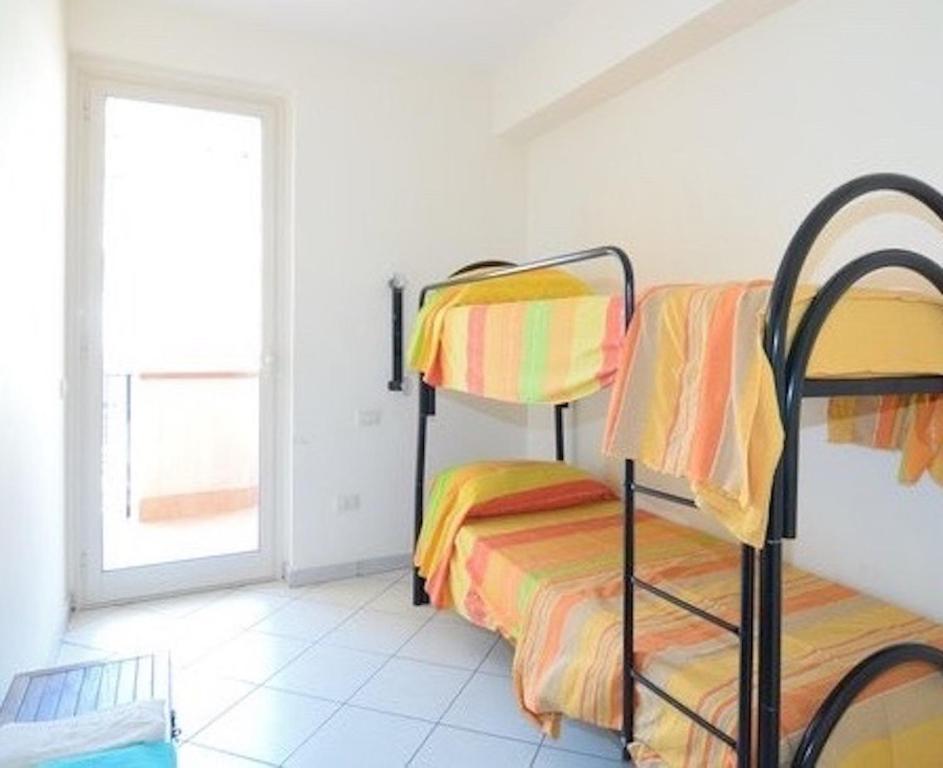 ニッツァ・ディ・シチーリアにあるCase Vacanza Alega Mareのベッドルーム1室(二段ベッド2台、窓付)が備わります。