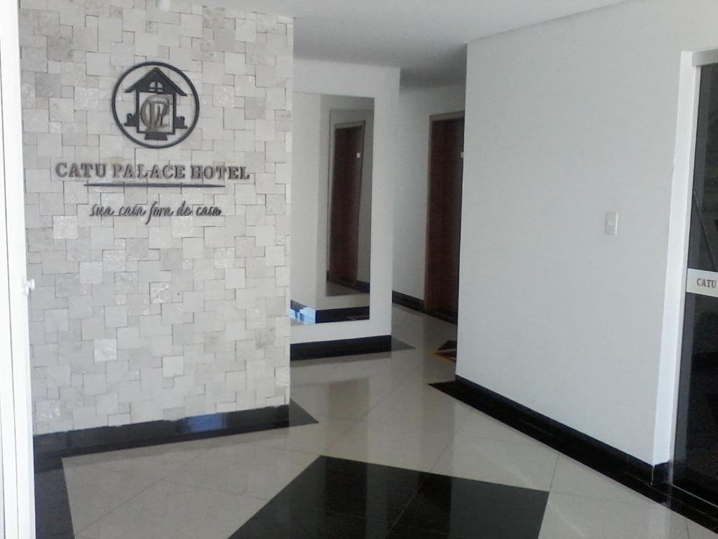 una habitación con una pared con un cartel. en Catu Palace Hotel en Rondonópolis
