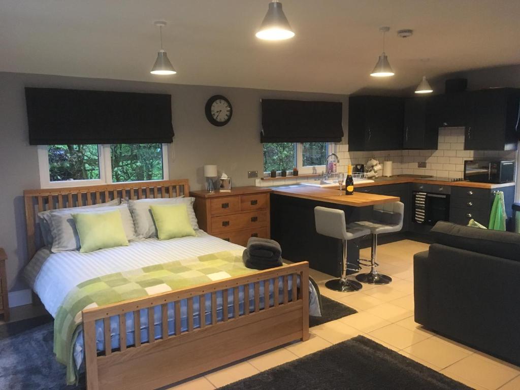 a bedroom with a bed and a kitchen at Summer House, Glassonby in Penrith