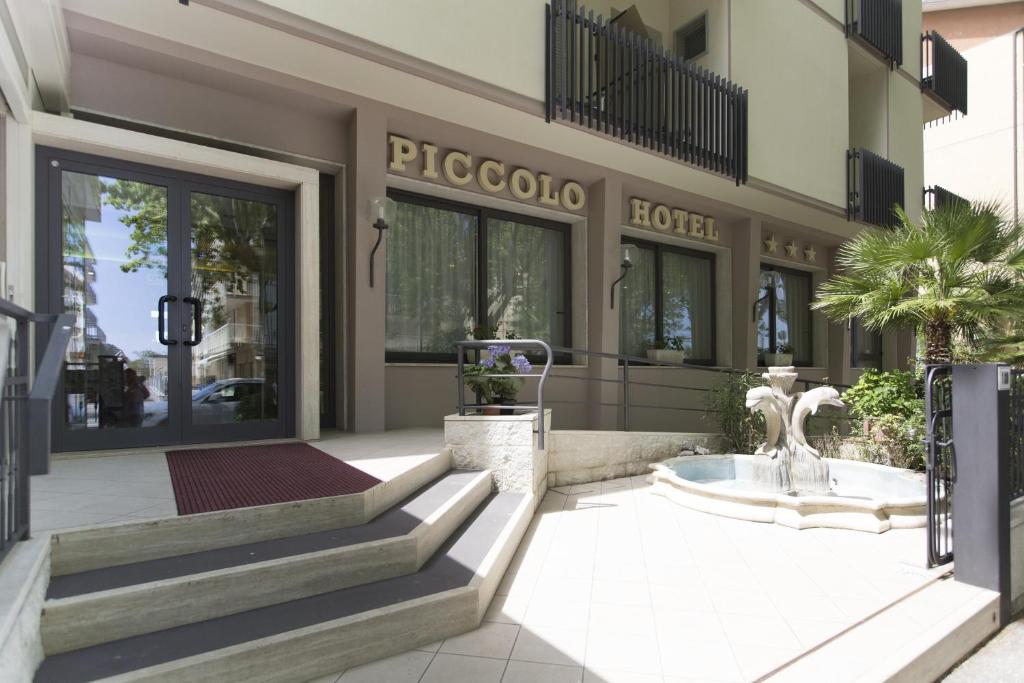 a building with a fountain in front of a building at Piccolo Hotel in Cesenatico