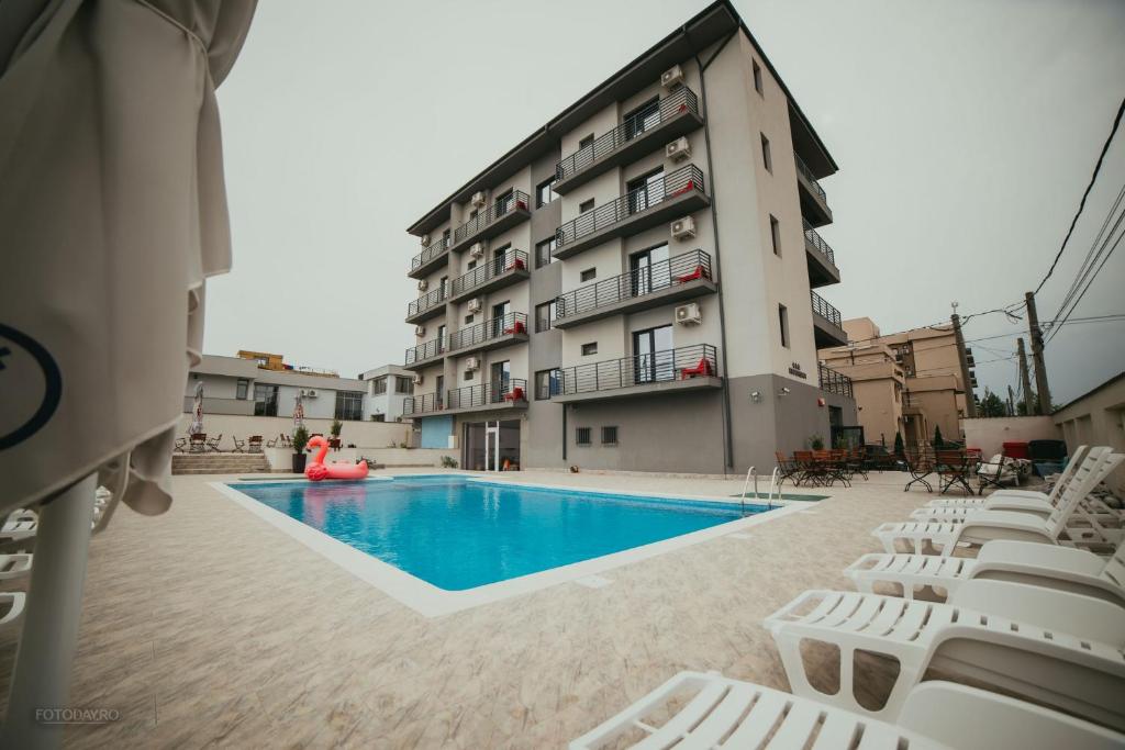 a hotel with a swimming pool in front of a building at Kharisma Hotel in Mamaia Nord
