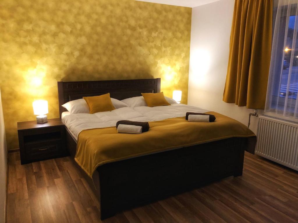 een slaapkamer met een groot bed met 2 lampen erop bij Villa Rustica in Bešeňová