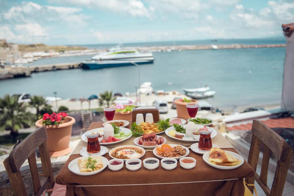 - une table avec de la nourriture et une vue sur l'océan dans l'établissement Aspava Butik Hotel, à Bozcaada