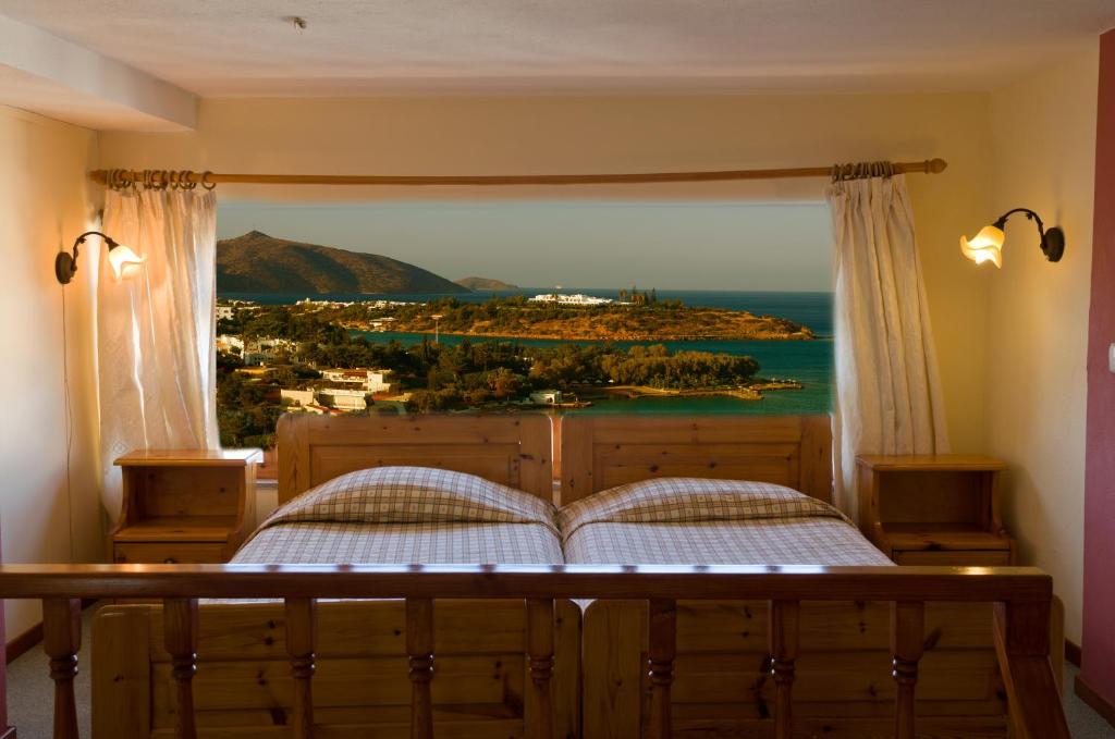 a bedroom with a bed with a view of the ocean at Eleni Studios in Agios Nikolaos