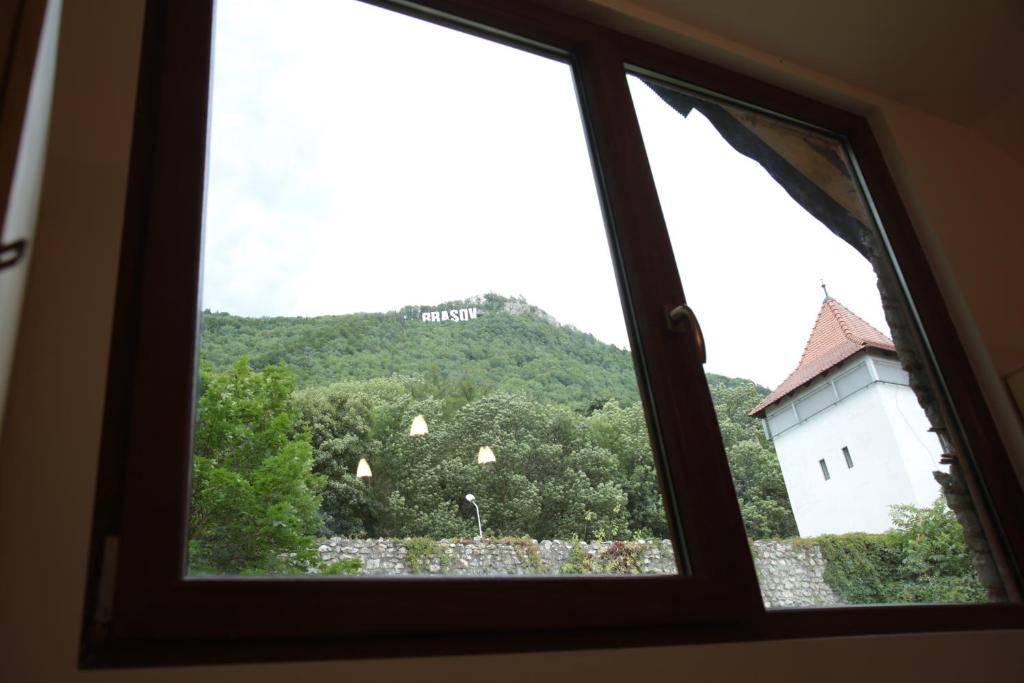 una ventana con vistas a un castillo y una colina en Downtown Hostel en Brasov