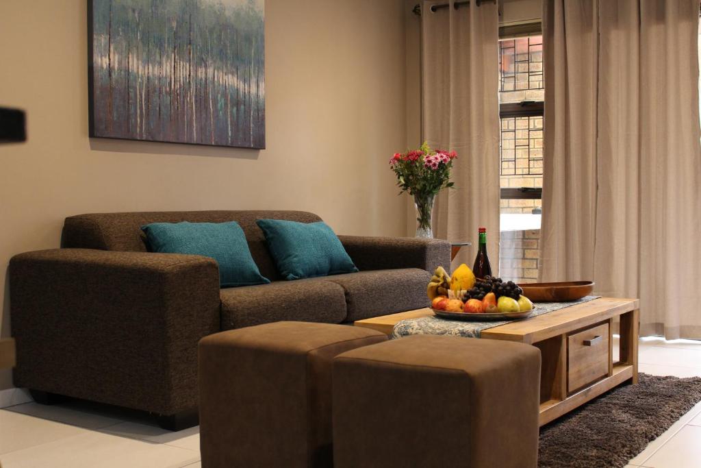 ein Wohnzimmer mit einem Sofa und einem Tisch mit Obst in der Unterkunft DCS Accommodation Cape Gate in Durbanville