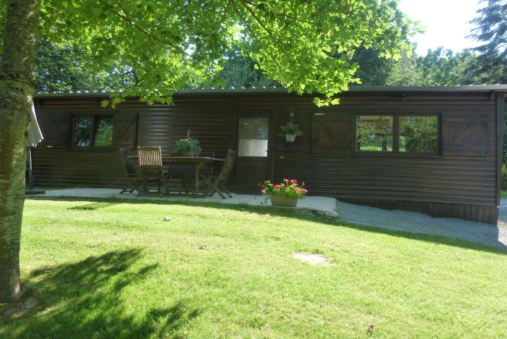 a cabin with a table and chairs in a yard at Relais Du Saussay in Pertheville-Ners