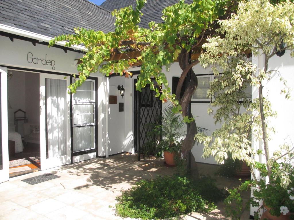 una puerta delantera de una casa blanca con un árbol en Invergara, en Ciudad del Cabo