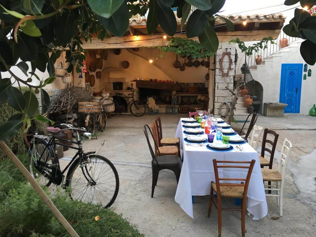 uma mesa com uma toalha de mesa branca no pátio em Lughia em Tortolì
