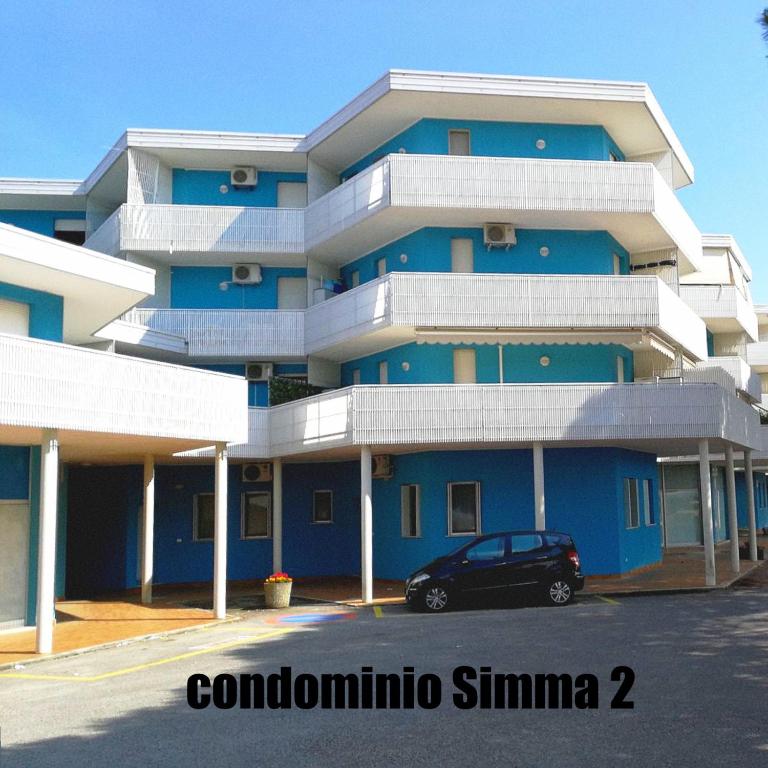 a blue building with a car parked in front of it at Condominio Simma in Bibione